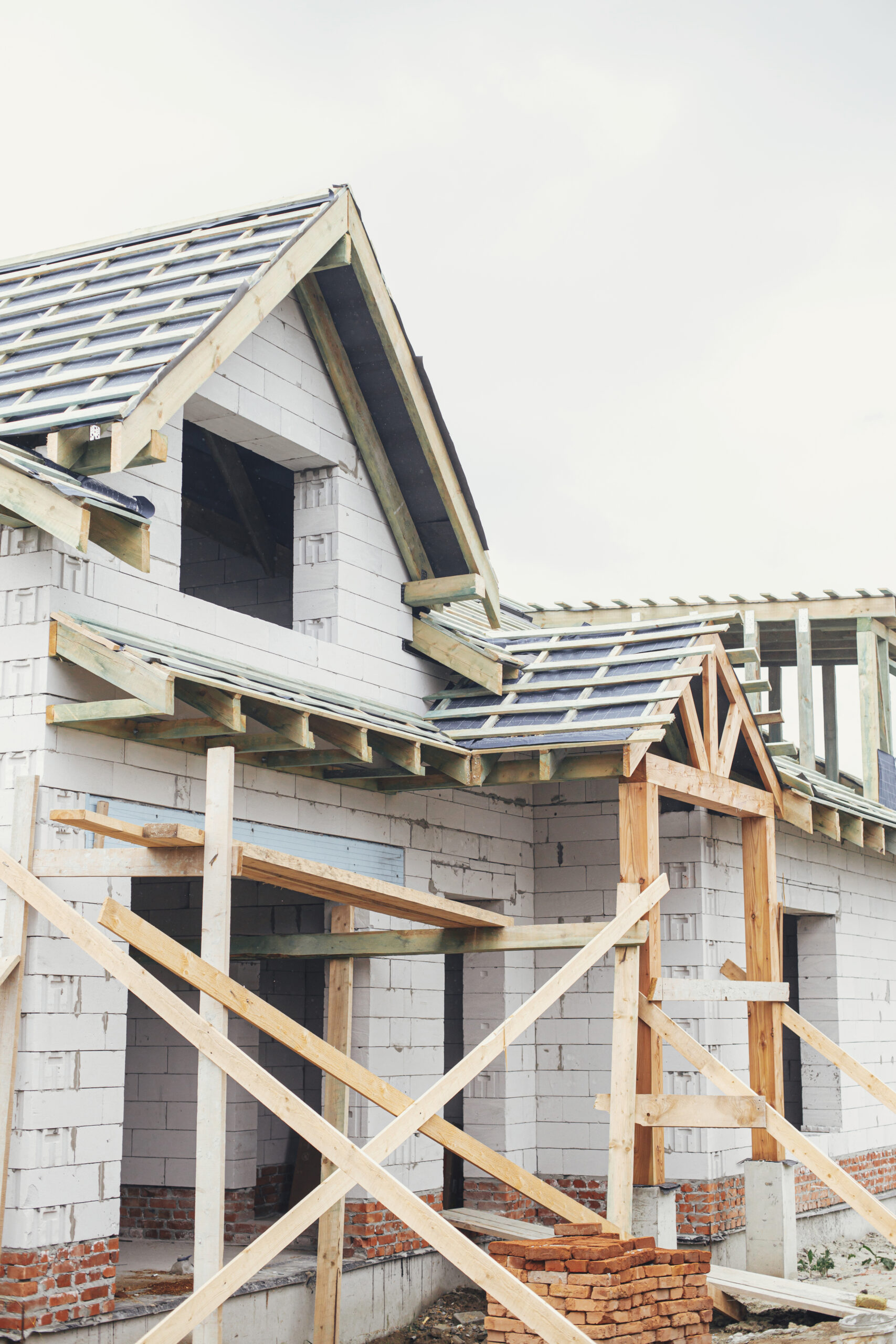 Unfinished modern farmhouse building. Wooden roof framing of man